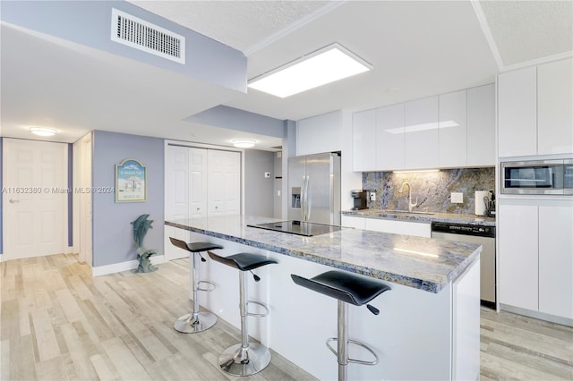 kitchen with white cabinetry, a center island, and stainless steel appliances