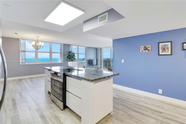 kitchen with dark stone countertops, light hardwood / wood-style flooring, stainless steel electric range, and white cabinets