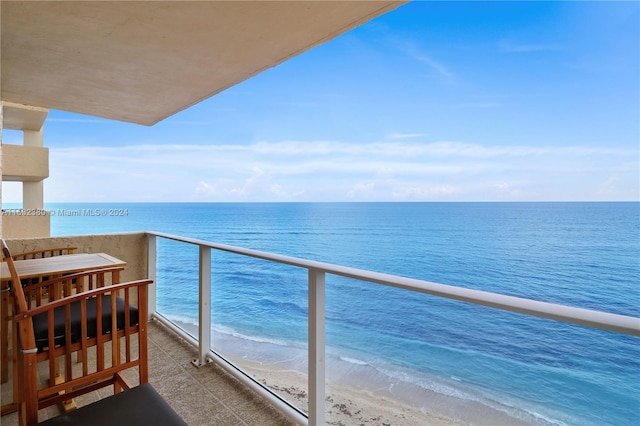 balcony featuring a water view and a view of the beach