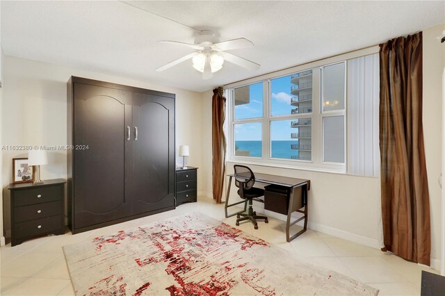 tiled bedroom with a water view, a textured ceiling, and ceiling fan