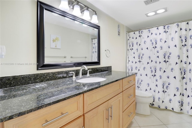 bathroom with tile patterned flooring, vanity, toilet, and walk in shower