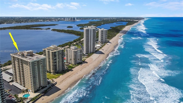 birds eye view of property with a water view and a beach view