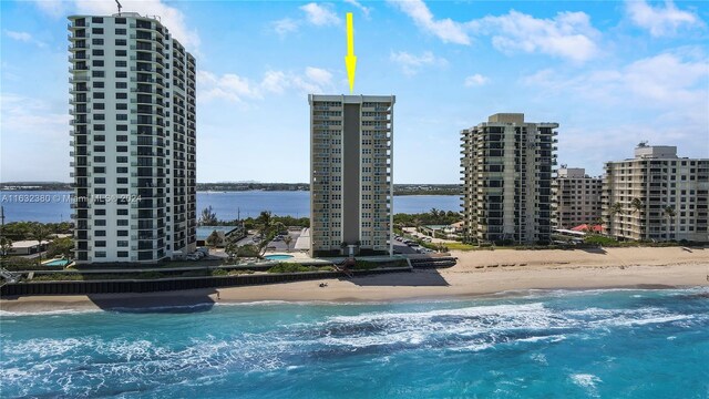 view of swimming pool featuring a water view and a beach view