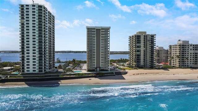 view of swimming pool with a water view and a beach view