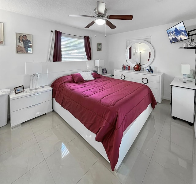 tiled bedroom with a textured ceiling and ceiling fan