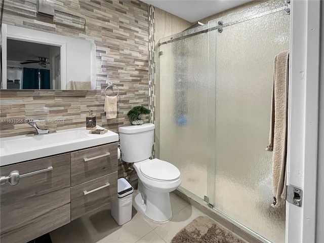 bathroom with tile patterned flooring, backsplash, toilet, vanity, and tile walls