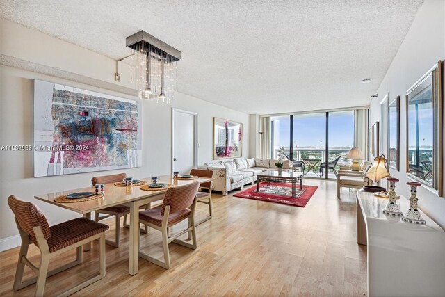 dining area featuring a textured ceiling, floor to ceiling windows, and light hardwood / wood-style floors