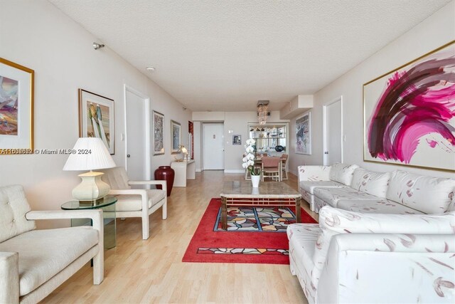 living room with a textured ceiling and light hardwood / wood-style flooring