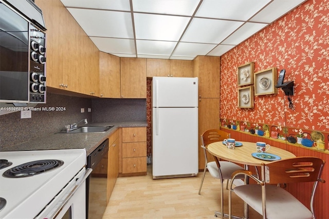 kitchen with sink, white appliances, and light hardwood / wood-style flooring