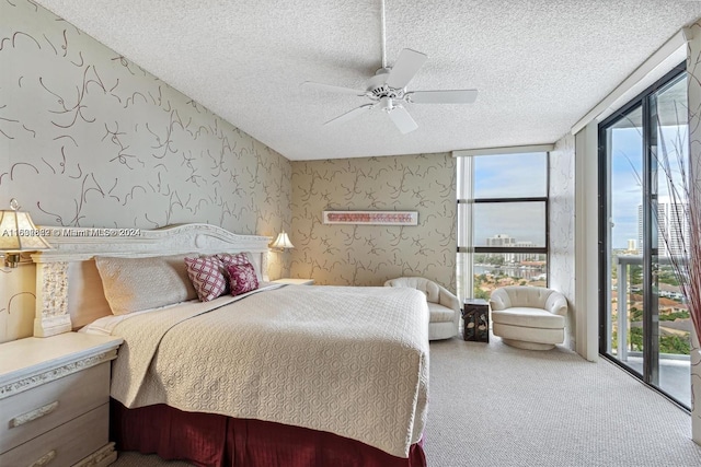 bedroom with ceiling fan, access to outside, multiple windows, and a textured ceiling