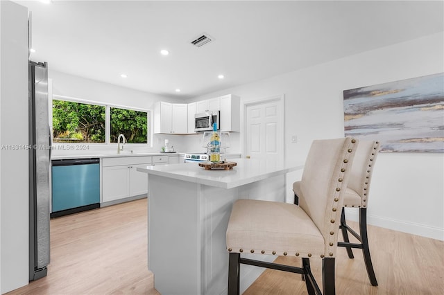 kitchen featuring light hardwood / wood-style flooring, appliances with stainless steel finishes, sink, and white cabinetry