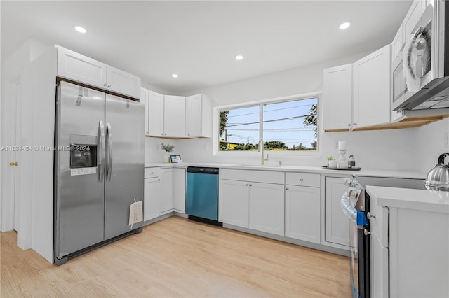 kitchen with light hardwood / wood-style flooring, stainless steel appliances, sink, and white cabinetry