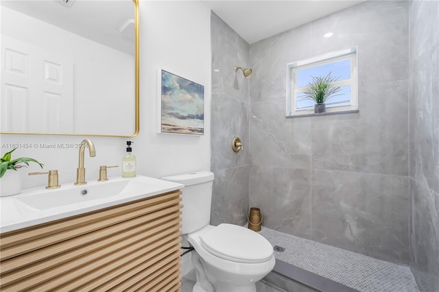 bathroom featuring vanity, toilet, and tiled shower