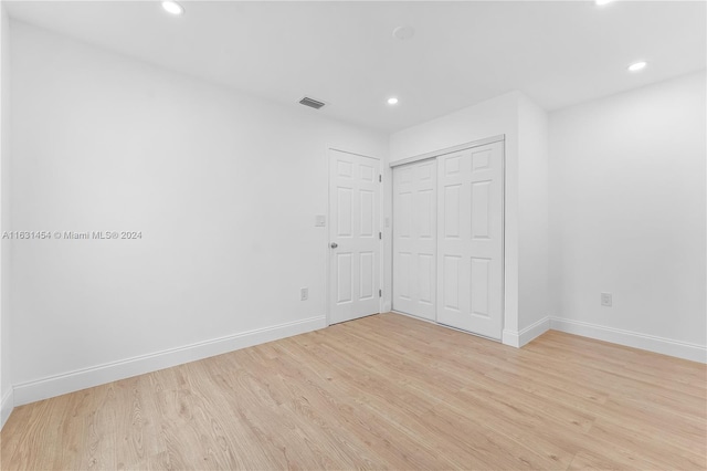 unfurnished bedroom featuring light hardwood / wood-style flooring and a closet