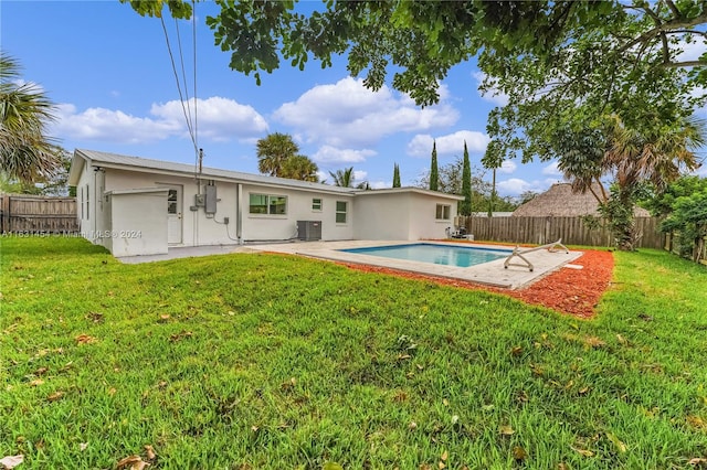 back of property featuring a yard, a patio, a fenced in pool, and cooling unit