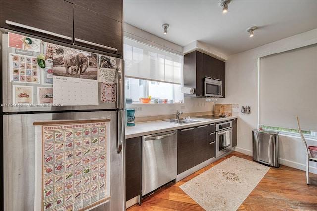 kitchen featuring sink, stainless steel appliances, light hardwood / wood-style flooring, and dark brown cabinets