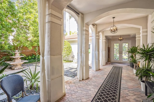 exterior space with french doors and a notable chandelier