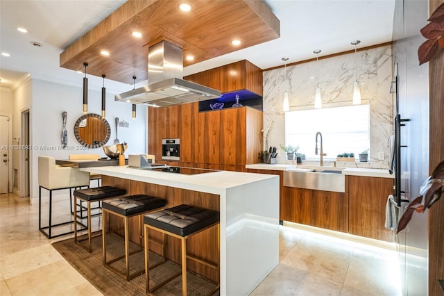 kitchen featuring a breakfast bar, sink, island exhaust hood, a kitchen island, and black electric cooktop