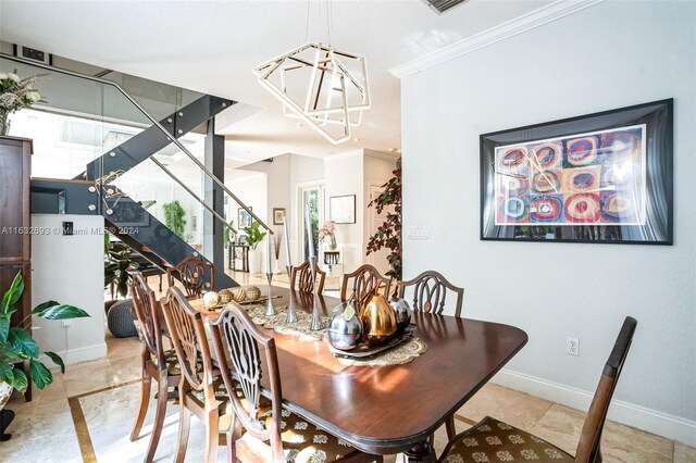 dining area with crown molding and a chandelier