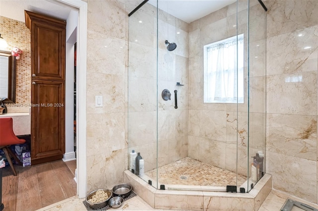 bathroom with a shower with door and hardwood / wood-style flooring