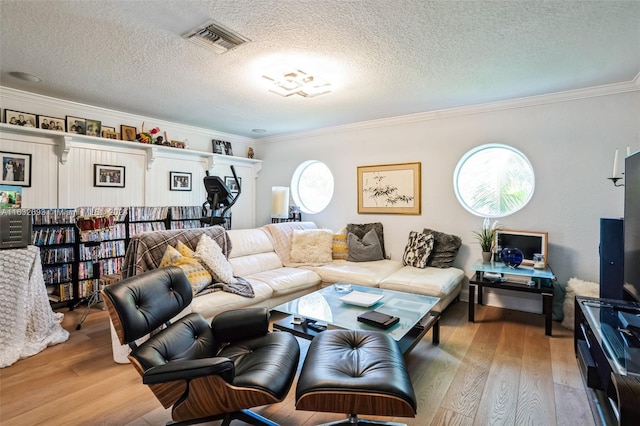 living room with a textured ceiling, crown molding, and hardwood / wood-style floors