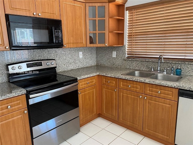 kitchen with tasteful backsplash, sink, light tile patterned floors, and appliances with stainless steel finishes