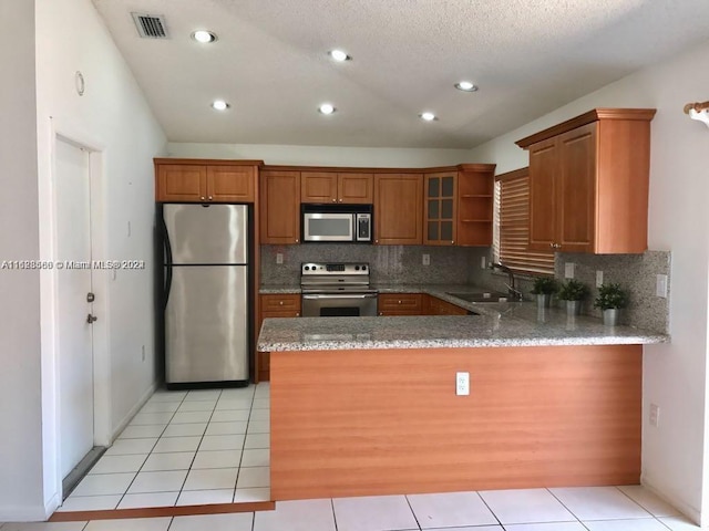 kitchen with tasteful backsplash, kitchen peninsula, sink, and appliances with stainless steel finishes