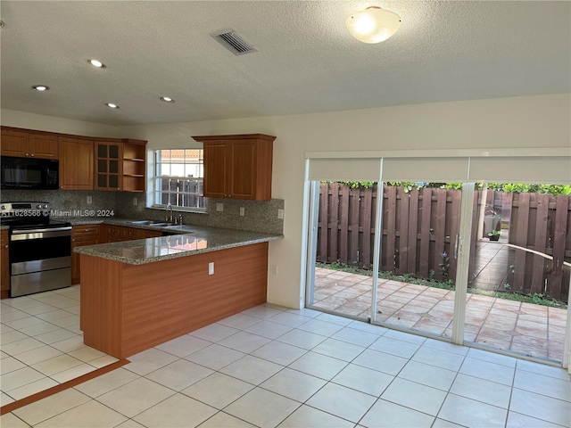 kitchen with kitchen peninsula, tasteful backsplash, stainless steel range with electric cooktop, and dark stone countertops