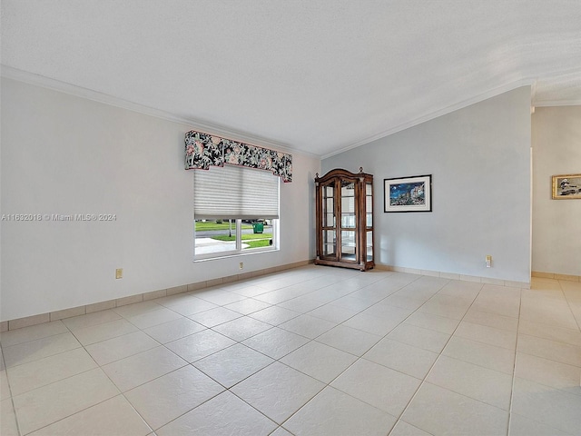 tiled spare room featuring crown molding and lofted ceiling