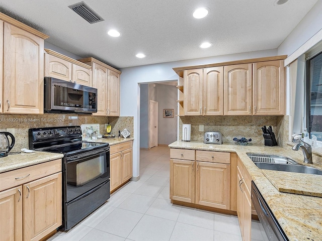 kitchen with tasteful backsplash, sink, light brown cabinets, and black appliances