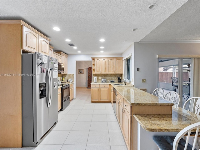 kitchen with black appliances, a kitchen bar, decorative backsplash, kitchen peninsula, and light brown cabinets