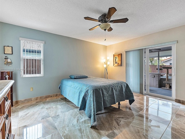 bedroom featuring access to exterior, a textured ceiling, and ceiling fan