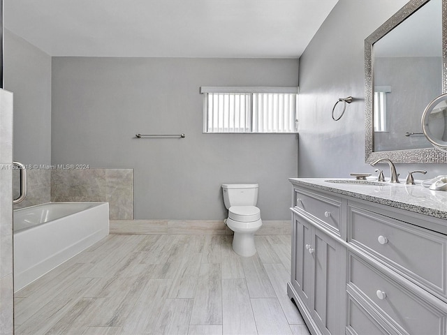 bathroom with vanity, toilet, and a bathing tub