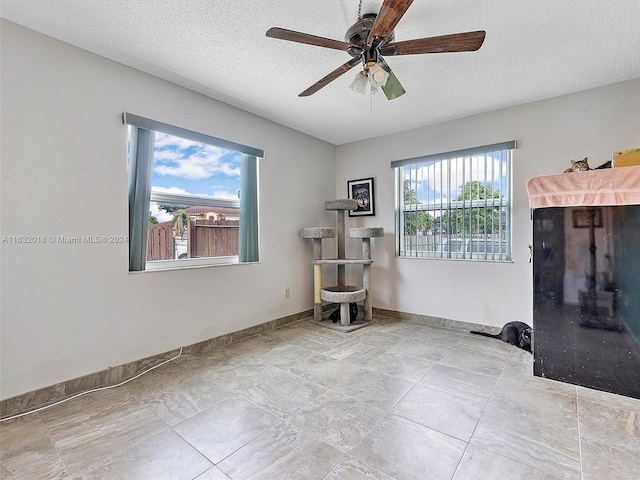 spare room with ceiling fan and a textured ceiling