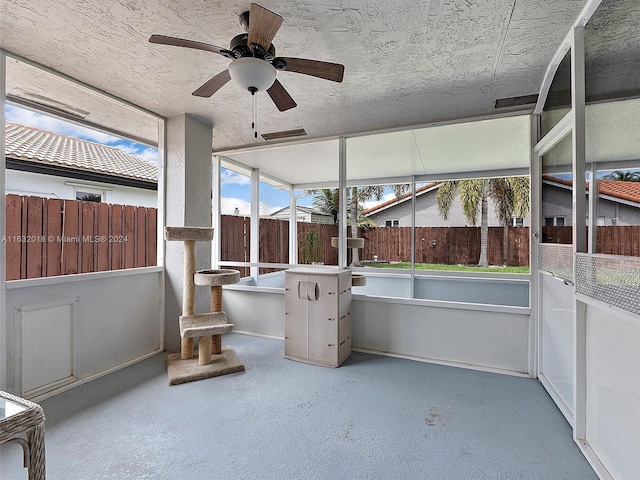 unfurnished sunroom featuring ceiling fan