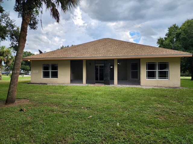 rear view of property with a yard