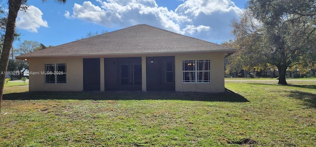 rear view of house featuring a lawn and a sunroom