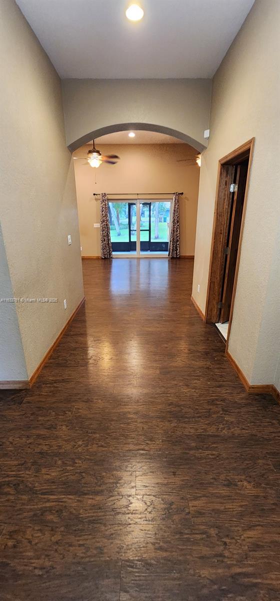 unfurnished room with ceiling fan and dark wood-type flooring