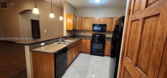 kitchen featuring a kitchen bar, kitchen peninsula, decorative light fixtures, black appliances, and sink