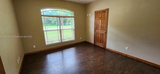 unfurnished room featuring a healthy amount of sunlight and dark hardwood / wood-style floors