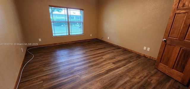 unfurnished room featuring dark wood-type flooring