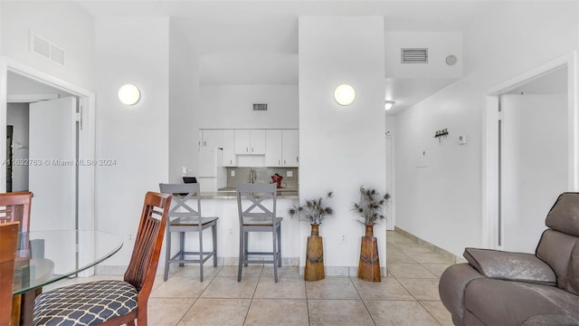 tiled living room featuring a towering ceiling