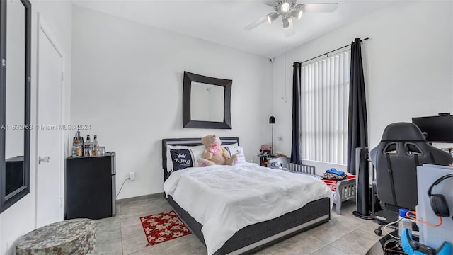 bedroom with ceiling fan, baseboards, and light tile patterned floors