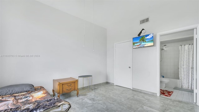 bedroom with ensuite bath, visible vents, and tile patterned floors