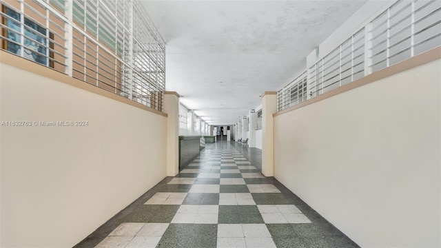 hall with tile patterned floors