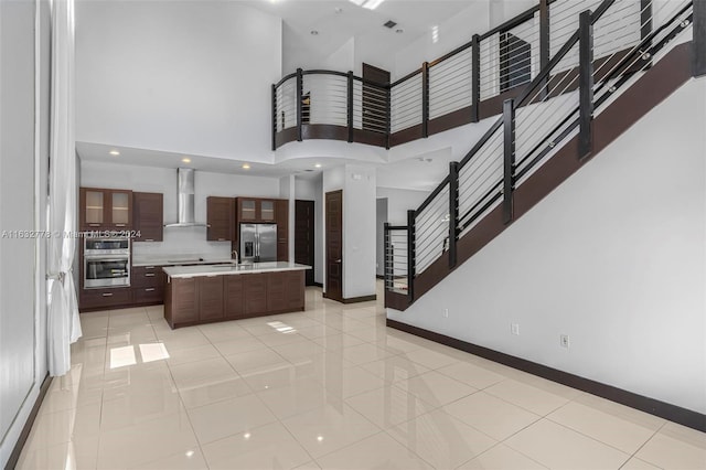 interior space with light tile patterned flooring, sink, and a towering ceiling