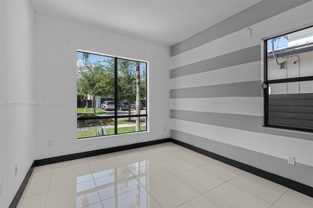 tiled empty room featuring plenty of natural light