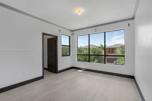 unfurnished room with crown molding and light hardwood / wood-style flooring