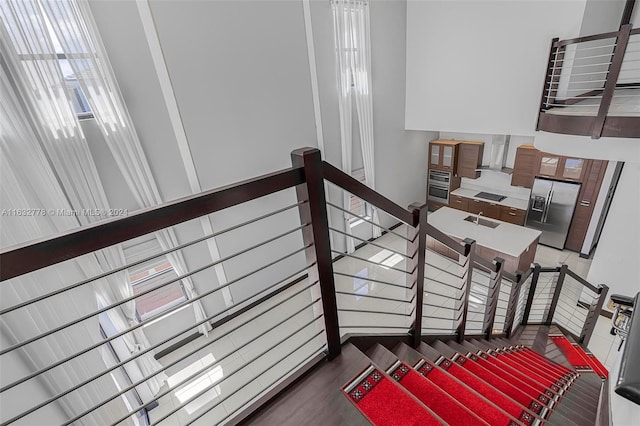 interior space featuring sink, hardwood / wood-style flooring, and a towering ceiling