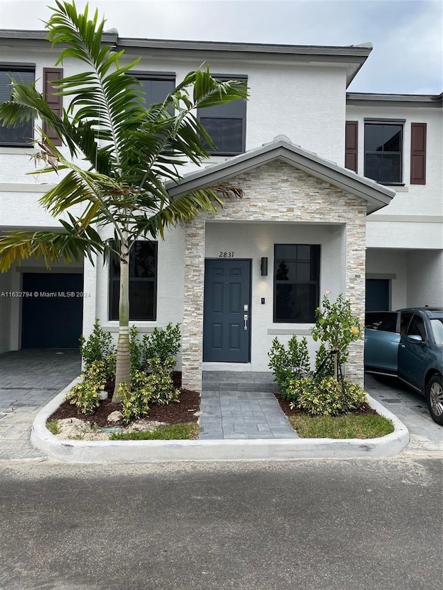 doorway to property featuring stone siding and stucco siding